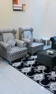 een woonkamer met twee banken en een tafel op een tapijt bij Zaer Al Fakhama Hotel Apartments in Tabuk
