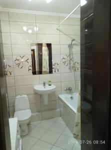 een badkamer met een toilet, een wastafel en een spiegel bij Люкс апартаменты на Позняках in Kiev