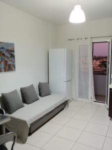 un divano in una camera bianca con finestra di Amazing Sea View Apartment ad Amoudara Herakliou