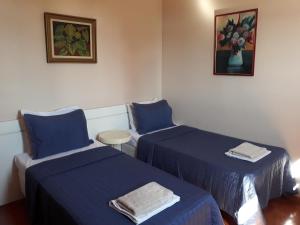 two beds in a room with blue sheets at Apartamento Uberlândia - BH in Belo Horizonte