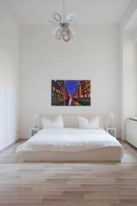 una camera bianca con letto e ventilatore a soffitto di The Hidden Pearl a Berlino