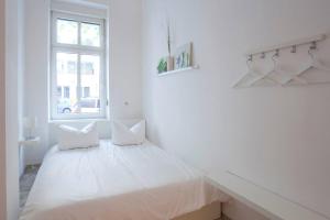 Posto letto in una camera bianca con finestra di The Hidden Pearl a Berlino
