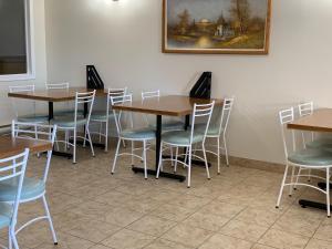 a room with tables and chairs and a painting on the wall at Westway Inn Motel in Neepawa