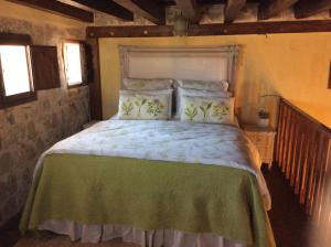 een slaapkamer met een groot bed en een groene deken bij George & Alexandra's Apartments in Rhodos-stad