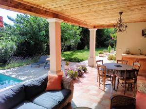 a patio with a couch and a table under a pavilion at Location Vacances Gillardin in Maussane-les-Alpilles