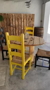 a wooden table and chairs with a yellow table and chairs at Casa 40th-Music Wood House in Óbidos