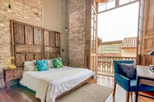 a bedroom with a bed and a blue chair at Socialtel Candelaria Bogotá in Bogotá