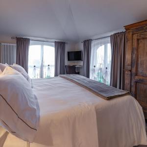1 dormitorio con 1 cama blanca grande y ventanas en Le mongolfiere en Mondovì