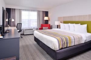 Un pat sau paturi într-o cameră la Country Inn & Suites by Radisson, Tinley Park, IL