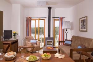 a living room with a couch and a fireplace at Madame Vacances Les Cottages De Valjoly in Eppe-Sauvage