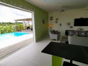 a living room with a view of a swimming pool at La Villa Soleil :) in Sainte-Anne