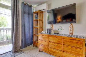 a room with a dresser with a tv on the wall at Kona Bali Kai #165 in Kailua-Kona