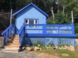 een blauw huis met een trap en een veranda bij Hillside Motel in Lake George