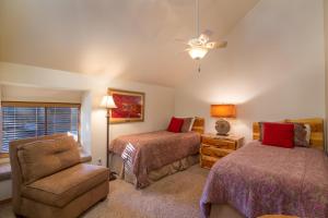 a bedroom with two beds and a chair at Quelah Condo #30 is a 3 bedroom, newly remodeled vacation condo that can accommodate up to 6 guests. Swim at the Quelah Complex Pool! in Sunriver