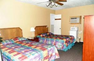 a hotel room with two beds and a fan at Interstate Motel in Wills Point