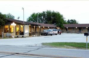a parking lot with cars parked in front of a building at Interstate Motel in Wills Point