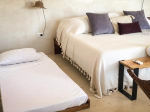 Habitación con 2 camas con almohadas y mesa. en Kuka y Naranjo, en Mérida 37 fotos más