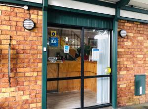 a brick building with a store front with a window at Tudor Court Motor Lodge in Auckland