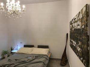 a bedroom with a bed and a chandelier at Casitta in Mascali +26 photos