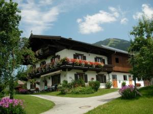 a house with flowers on the side of it at Neukumhof in Westendorf