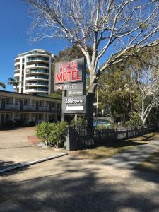 una señal de hotel de motel frente a un edificio en Forster Beach Motel en Forster