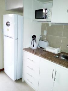a kitchen with a white refrigerator and a sink at Indalo in Termas del Daymán