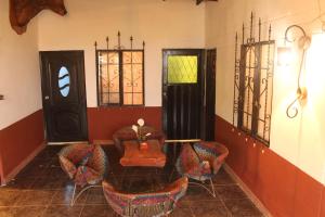 a room with chairs and a table and a door at Green Hostal Popayan in Popayan