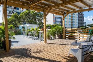 a patio with tables and chairs on a wooden deck at Santurcia Hostel in San Juan