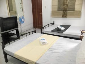 um quarto com duas camas e uma TV em Silang Near Tagaytay Transient Rooms for Family em Tagaytay