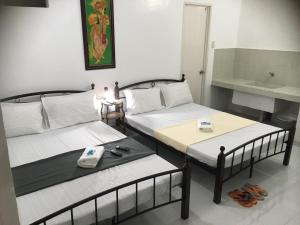 2 camas individuais num quarto com um lavatório em Silang Near Tagaytay Transient Rooms for Family em Tagaytay