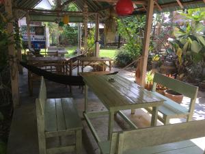 a group of tables and chairs and a hammock at Orchid Guest House in Trat