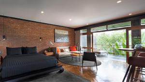 a bedroom with a bed and a brick wall at Chapung Sebali in Ubud