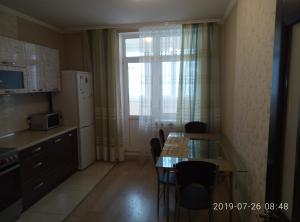 een keuken met een tafel en stoelen en een raam bij Люкс апартаменты на Позняках in Kiev