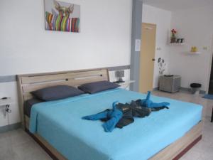 una camera con letto e piumone blu di Similan Hotel a Bang Tao Beach
