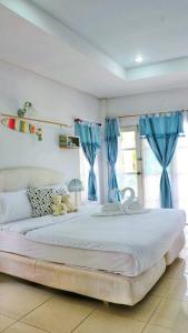 a bedroom with a large bed with blue curtains at Prathana Garden Beach Resort in Hua Hin