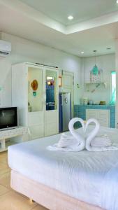 a bedroom with a bed with two swans on it at Prathana Garden Beach Resort in Hua Hin