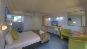 克里夫蘭的住宿－克利夫蘭海灣航空汽車旅館，酒店客房配有一张床、一张桌子和一把椅子。