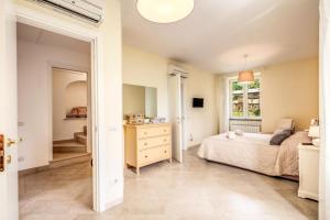 a bedroom with a bed and a dresser and a window at Casa Rosada in Massa Lubrense +21 photos