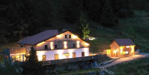 a house with lights on top of it at night at Le Cabanon de LaFermeDuNol in La Bresse