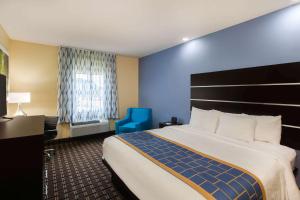 A bed or beds in a room at Days Inn by Wyndham Baton Rouge Airport