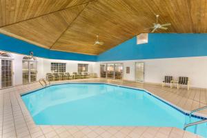 a large swimming pool with a wooden ceiling at Super 8 by Wyndham Reedsburg in Reedsburg