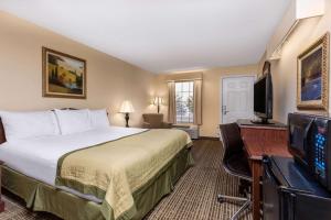 a hotel room with a bed and a flat screen tv at Baymont by Wyndham Easley/Greenville in Easley