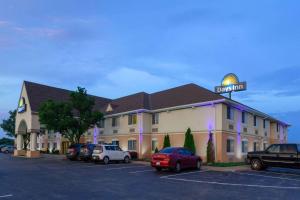 a hotel with cars parked in a parking lot at Days Inn by Wyndham Milan Sandusky South in Milan