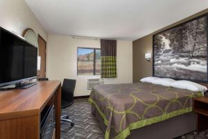 a hotel room with a bed and a flat screen tv at Super 8 by Wyndham Dubois in Dubois