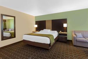 a hotel room with a bed and a chair at Travelodge by Wyndham Angels Camp CA in Angels Camp