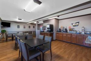 un restaurante con mesa, sillas y barra en Travelodge by Wyndham Angels Camp CA, en Angels Camp