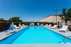 a swimming pool with chaise lounge chairs and a swimming pool at Baymont by Wyndham Easley/Greenville in Easley