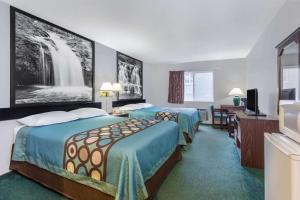 a hotel room with two beds and a television at Super 8 by Wyndham Reedsburg in Reedsburg