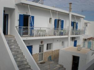 a white building with blue windows and a staircase at Chrysa in Antiparos