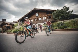 un gruppo di persone che vanno in bicicletta di fronte a un edificio di HUUS Gstaad a Gstaad